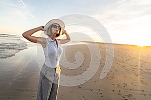 Portrait of calm, relaxed girl, carefree traveler woman enjoying summer vacation, walking on the sandy beach