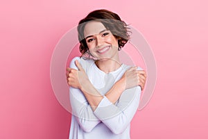 Portrait of candid girl hug herself enjoy self love wear pullover isolated over pastel color background