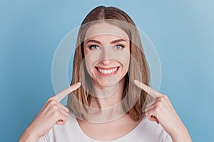 Portrait of candid healthy girl indicate forefingers toothy smile on blue background