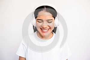 Portrait of candid young woman listening to music in headphones
