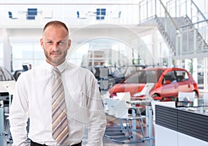 Portrait of car salesman in showroom