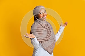 Portrait of carefree afro islamic girl in headscarf with spreaded arms