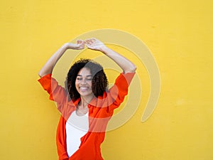 Portrait of a carefree smiling African American young girl on a yellow background