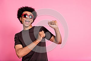 Portrait of carefree wavy hair man wear brown t shirt and sunglass rayban have fun chilling clubbing isolated on pink photo