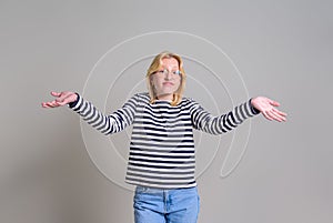 Portrait of careless businesswoman spreading hands and shrugging shoulders over white background