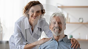 Portrait of caring female doctor support older patient
