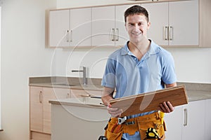 Portrait Of Carpenter Installing Fitted Kitchen