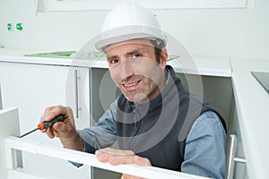 Portrait carpenter installing fitted kitchen