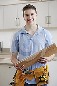 Portrait Of Carpenter Installing Fitted Kitchen photo