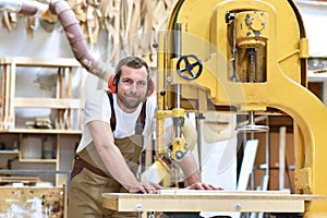 Portrait of a carpenter in work clothes and hearing protection i