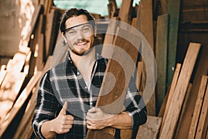 Portrait of Carpenter young SME furniture shop owner smiling in wood workshop look professional skilled real people handcraft