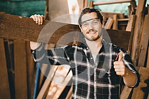 Portrait of Carpenter young SME furniture shop owner smiling in wood workshop look professional skilled real people handcraft