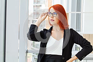 Portrait of a casual businesswoman with short red hair in a modern house.