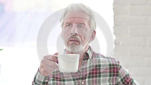 Portrait of casual old man drinking coffee