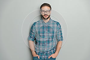 portrait of casual sexy guy wearing plaid shirt and glasses and posing
