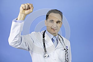 Portrait of a caucasian adult doctor. Raised up hand clenched into a fist.