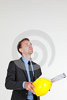 Portrait of  a caucasian architectual Engineer wearing hardhat looking at the construction layout drawing on white background copy