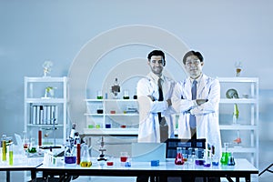Portrait of caucasian and asian in modern scientific laboratory working together