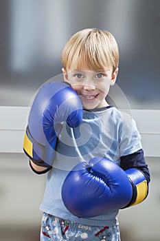 Portrait of Caucasian boy in casuals wearing boxing gloves photo