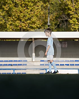 Portrait of Caucasian child boy entering a soccer stadium, dreaming of becoming professional player, soccer star. Copy space