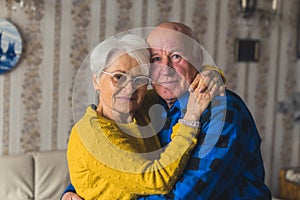 Portrait of an Caucasian European elderly couple smiling and embracing in vintage home interior