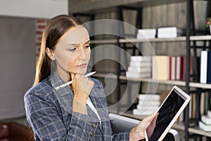 portrait of caucasian female executive thinking financial and working plan for employee on tablet and digital pen.