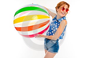 Cheerful woman with fair red hair holds a ball, picture isolated on white background