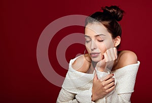 Portrait of caucasian female model standing with her eyes closed against red background