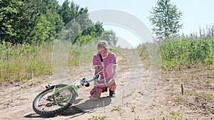 Portrait of a Caucasian girl 9-10 years old, a teenager, fell off her bike and suffers from pain. Leg injury.