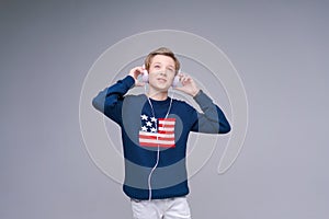Portrait caucasian guy teenager listens to music with headphones in blue