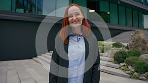 Portrait Caucasian happy joyful gorgeous red ginger haired business woman smiling charming toothy standing in city