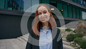 Portrait Caucasian happy joyful gorgeous red ginger haired business woman smiling charming toothy standing in city