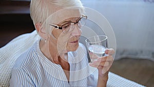portrait caucasian healthy senior adult woman holding glass drinking fresh mineral pure water at home. maintaining