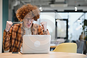 Portrait of Caucasian male freelancer in trendy apparel sitting at cafeteria table and doing remote work for programming