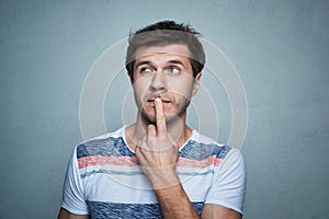 Portrait of caucasian man with think emotion on a gray background