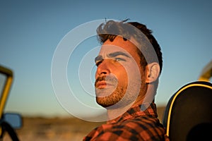 Portrait of caucasian man watching sunset in beach baggy