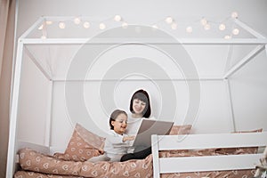 Portrait of caucasian mother with her cute preschool daughter, using laptop having video call