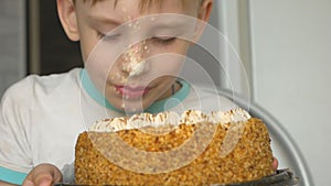 Portrait of Caucasian preschooler boy licks cake. The child eats dessert, having smeared his face with sweet protein cream. Humor