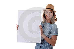 Portrait of caucasian smiling woman in summer hat holding white board, isolated over white background