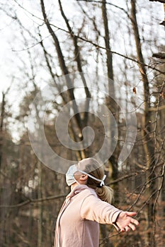 Portrait of caucasian sporty woman wearing medical protection face mask while relaxing by taking a deep breath in forest