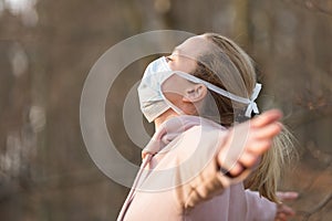 Portrait of caucasian sporty woman wearing medical protection face mask while relaxing by taking a deep breath in forest