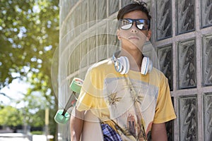 Portrait of caucasian teenage skater boy with sunglasses outdoors. Lifestyle concept