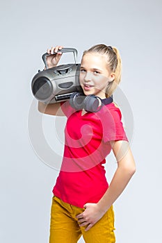 Portrait of Caucasian Teenager Blond Girl Posing With Oldtime Tape recorder and Headphones