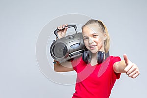 Portrait of Caucasian Teenager Blond Girl Posing With Oldtime Tape recorder and Headphones photo