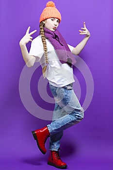 Portrait of Caucasian Teenager Girl in Coral Warm Knitted Winter Hat and Violet Scarf Showing V Gesture by Hands Over Purple