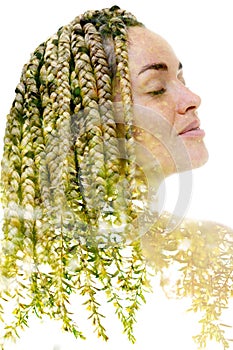 A portrait of a caucasian woman combined with an image of green leaves in a double exposure technique.
