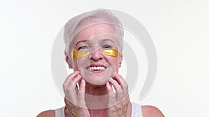 Portrait of Caucasian Woman in Gold Eye Patches on White Background