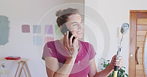 Portrait of a caucasian woman in quarantine during coronavirus pandemic, talking by phone