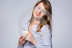 Portrait Caucasian women on gray studio background. Beautiful and smiling female model in white shirt. The concept of human