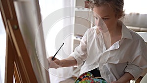 Portrait of caucasian young artist girl coloring on painting board at home. Attractive female drawing art picture